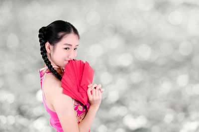 Portrait of smiling young woman holding envelopes