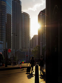 Silhouette of the two women walking toward the city in a sunset atmosphere.