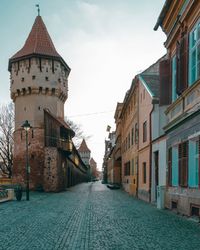 Narrow street amidst buildings against sky