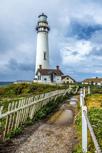 Lighthouse amidst buildings against sky