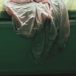 High angle view of woman covering face with bed