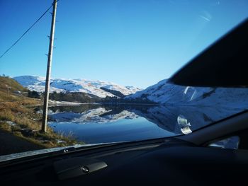 Snow covered mountains seen through car windshield