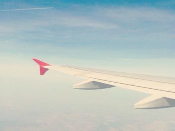 Cropped image of airplane flying over clouds