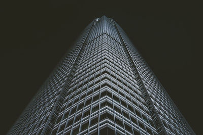 Low angle view of illuminated skyscraper against sky at night