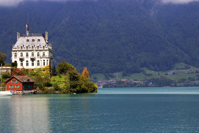 Buildings at waterfront against mountain