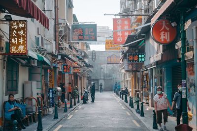 People on street amidst buildings in city