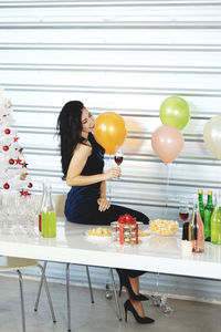 Woman holding balloons on table