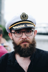 Portrait of bearded man wearing eyeglasses and cap in city