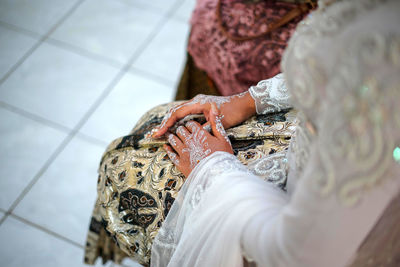 Low section of bride holding her hand 