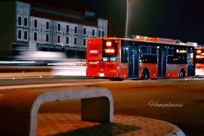 Red bus in city at night