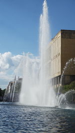 Water splashing in fountain against sky