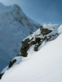 Exposed rock on a steep snowy slope on the side of a mountain in the alaska range