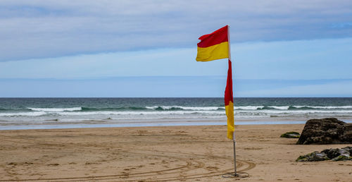 Lifeguard hut on beach against sky