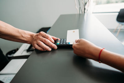 Unrecognizable woman paying in shop through contact less credit card. shopping