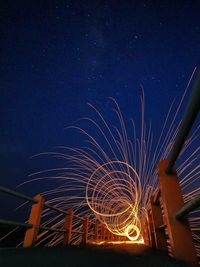 Illuminated light trails against sky at night