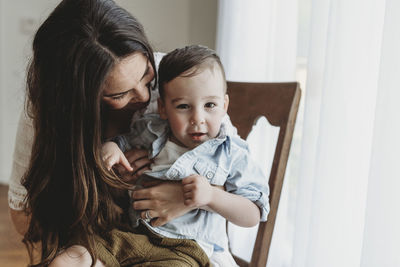 Close up of young preschool age boy being embraced by mother in studio