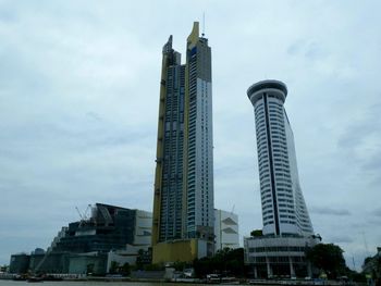 Low angle view of buildings against cloudy sky