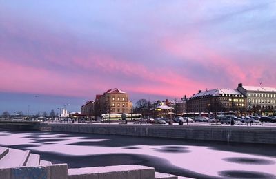 City buildings at waterfront during sunset