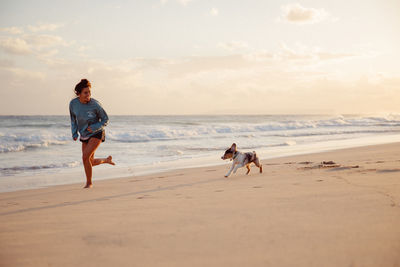 Friends walking on beach against sky