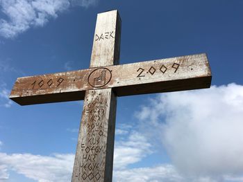 Low angle view of cross sign against sky