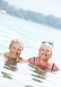 Portrait of senior couple swimming in lake