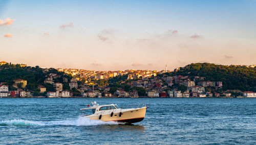 Nautical vessel on sea against buildings in city