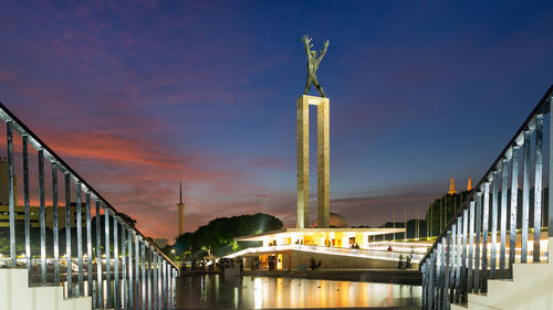 View of illuminated building against sky during sunset