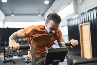 Sportsman exercising on exercise equipment in gym