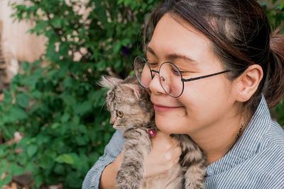 Close-up of young woman holding cat