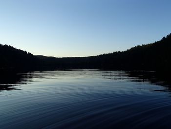 Scenic view of lake against clear blue sky