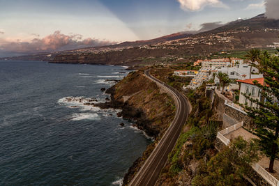 High angle view of townscape by sea against sky during sunset