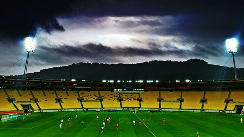 View of illuminated street light on field against cloudy sky