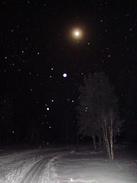 Scenic view of snow against sky at night