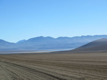 Scenic view of sandy beach against clear sky