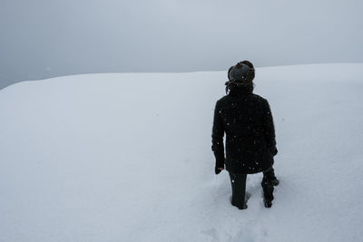 Rear view of person standing on snow field