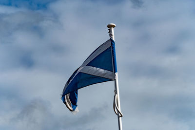 Low angle view of flag against blue sky