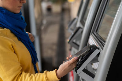 Midsection of man using mobile phone in bus