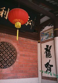 Low angle view of lantern hanging on wall