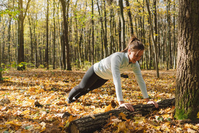 Girl doing fitness in nature on a sunny autumn forest