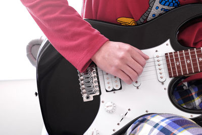 Midsection of man playing guitar