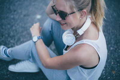 High angle view of woman wearing sunglasses while sitting on road