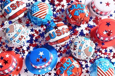 High angle view of colorful hats and balloons with confetti on table