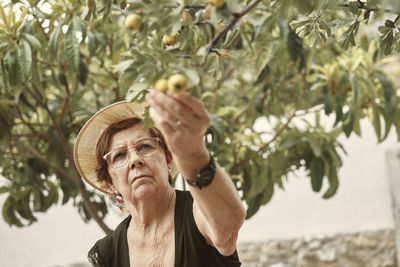 Portrait of woman wearing hat against trees