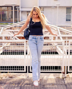 Portrait of young woman standing in city