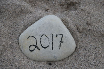 Close-up of text on sand