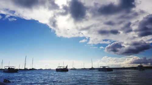 Sailboats in sea against sky