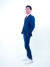 Full length of young man standing against white background