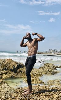 Full length of man photographing at beach against sky