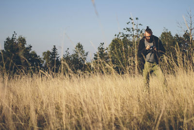 Woman standing on field against clear sky