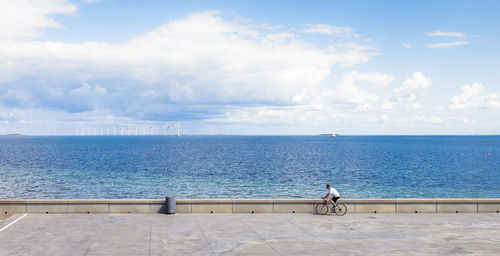 Man riding bicycle on shore